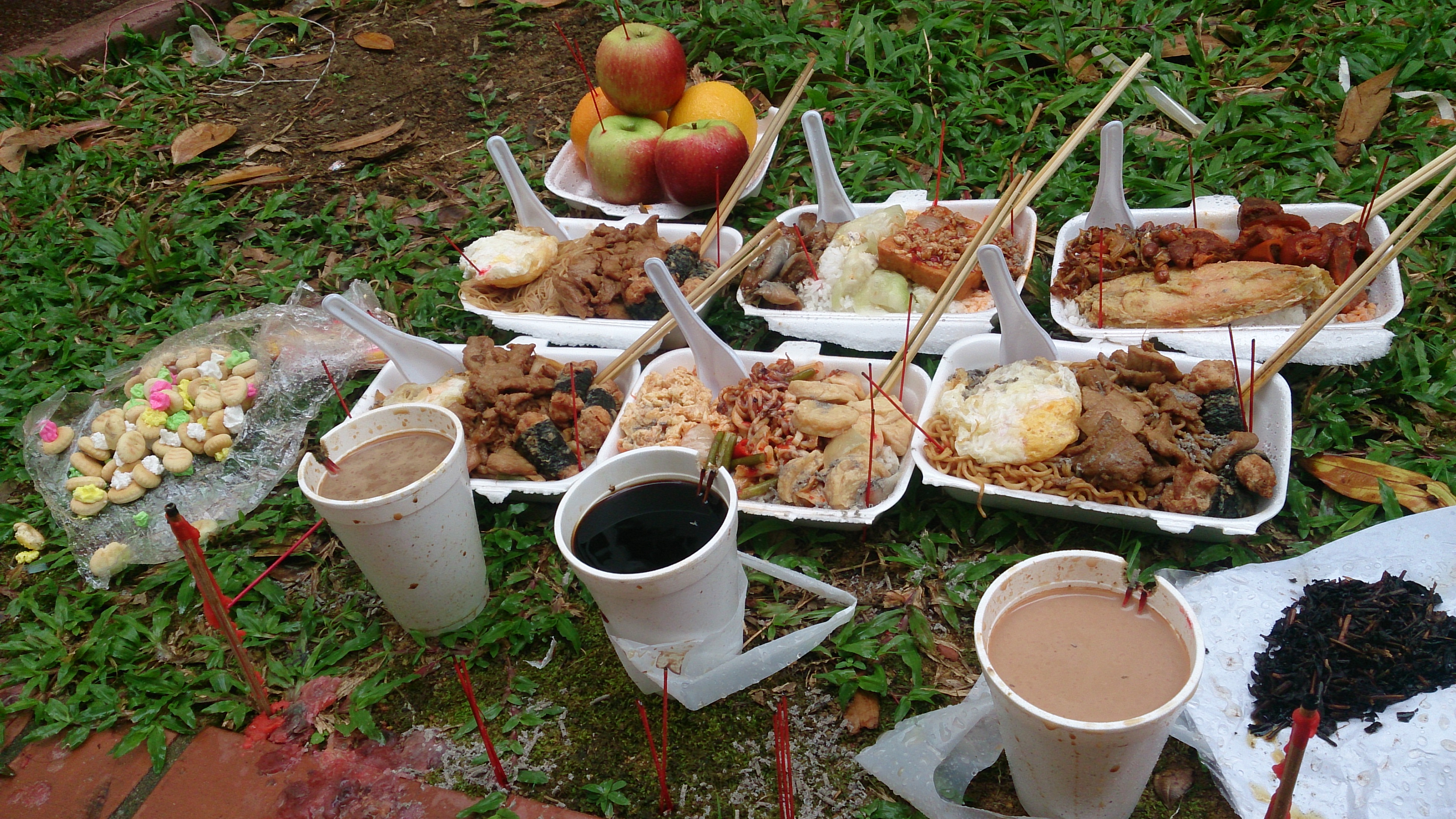 Hungry Ghost Festival offerings with joss paper and incense in Singapore